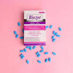 Biozee Biotin Zinc tablets box with blue supplements on pink background, Phlox wellness