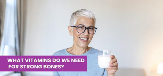 Smiling older woman with short gray hair and glasses holding a glass of milk, promoting strong bones and vitamins, Phlox wellness.